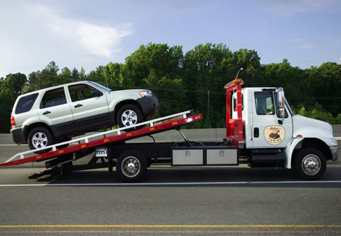 Anthony's Towing flatbed loading an SUV